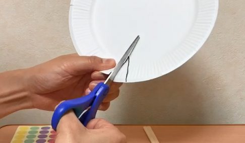 紙皿をハサミで切る